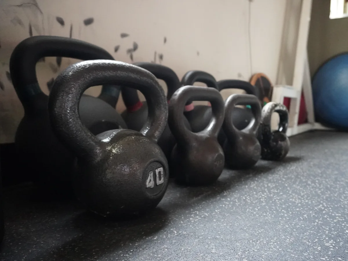 Commercial kettlebells in a premium gym setting, representing functional equipment planned for Q Fitness.