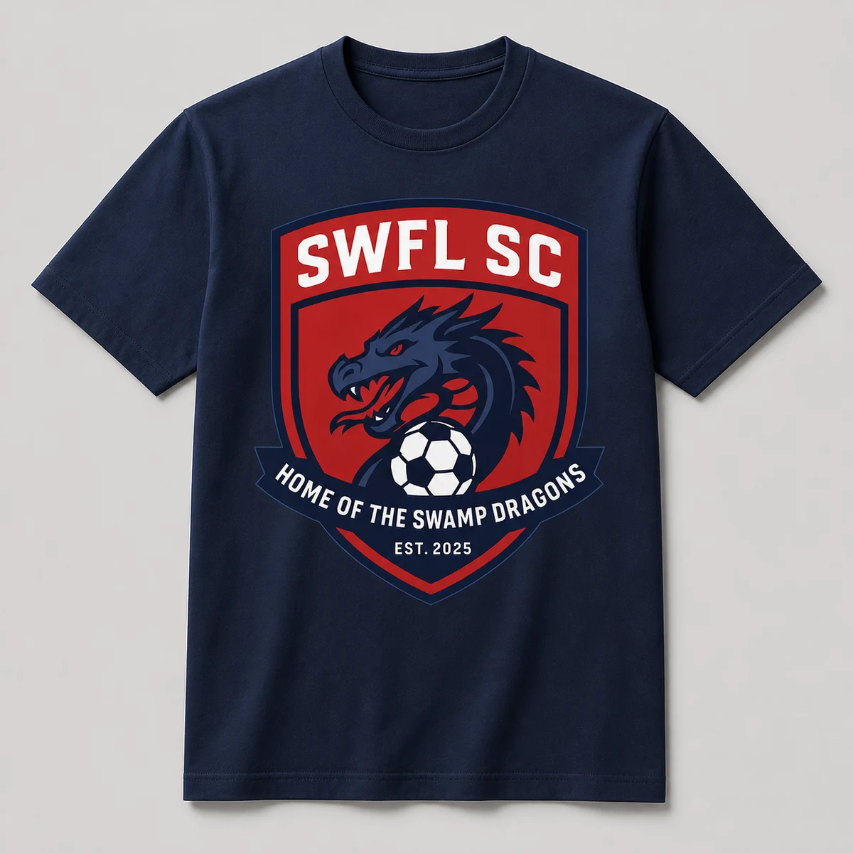Navy t-shirt with the SWFL SC shield: a dragon's head over a soccer ball, banner reading Home
                    of the Swamp Dragons, Est. 2025.