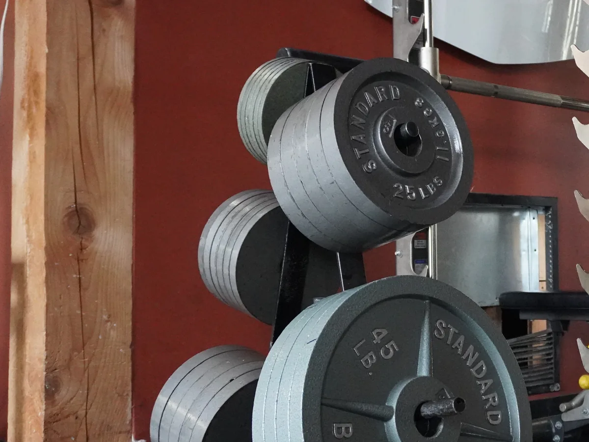 Commercial weight plates representing free-weight equipment planned for Q Fitness.